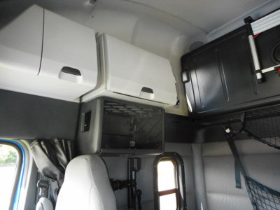 Freightliner Cascadia truck cab interior showing overhead compartments and storage shelves.
