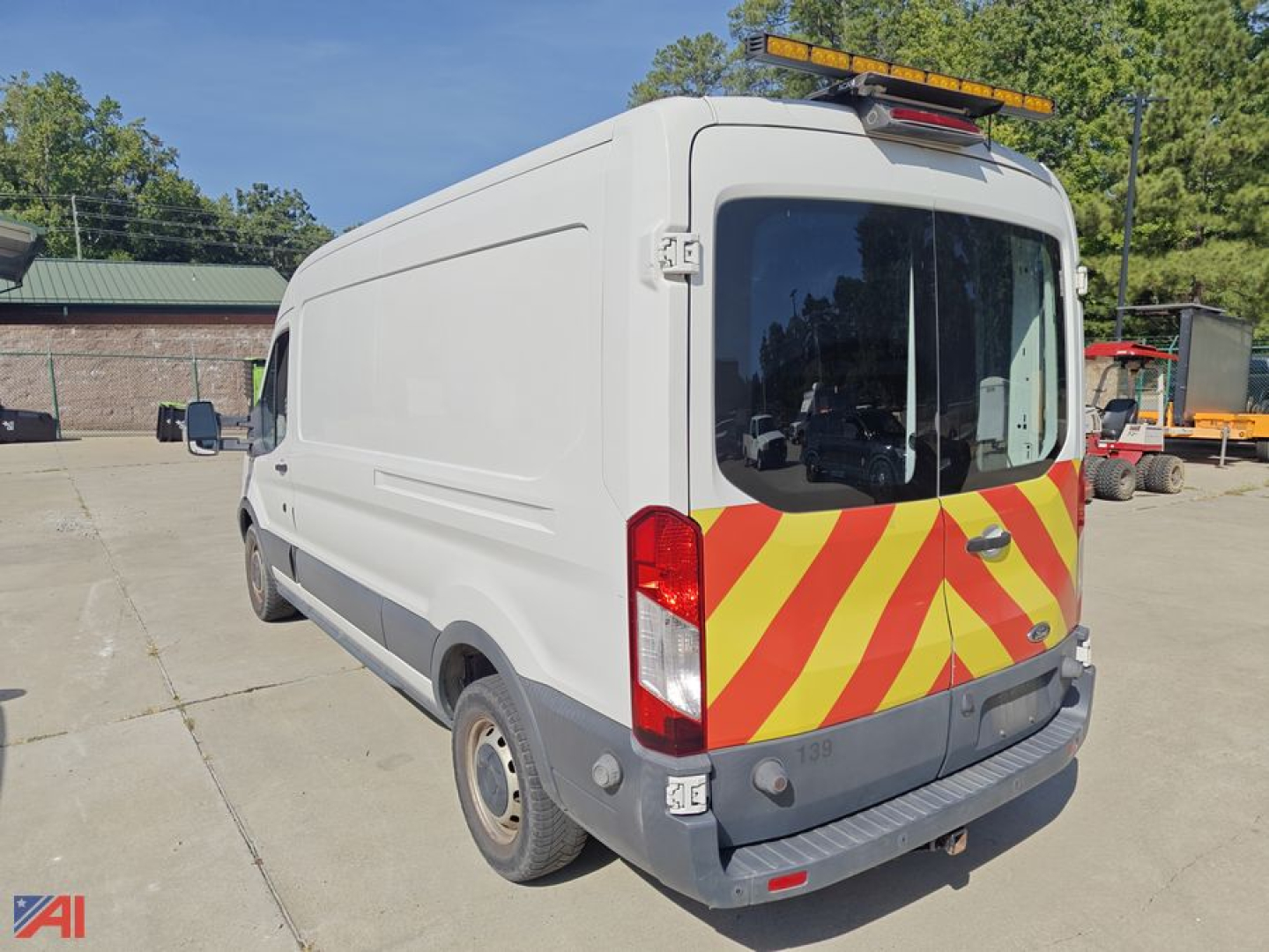 Ford Transit cargo van rear view showing high-visibility chevrons on the rear doors and roof beacon.