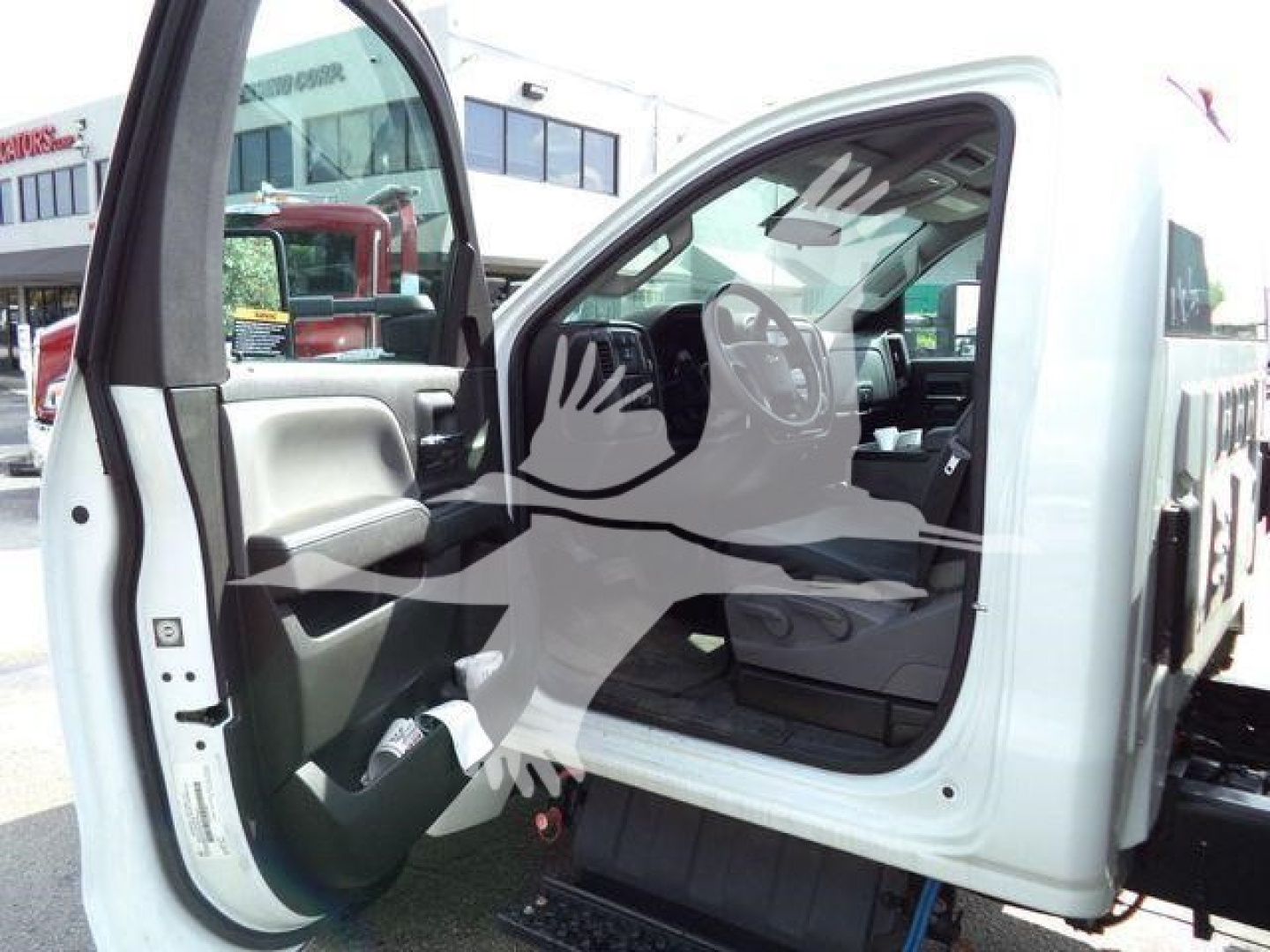 Truck cab interior visible with door open showing steering wheel and dashboard area.