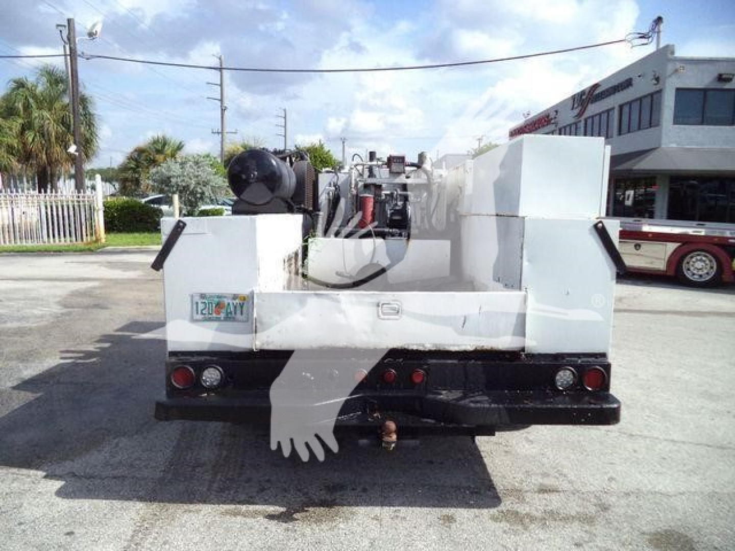 Truck bed showing utility equipment and hitch, rear view with bumper lights and license plate area.