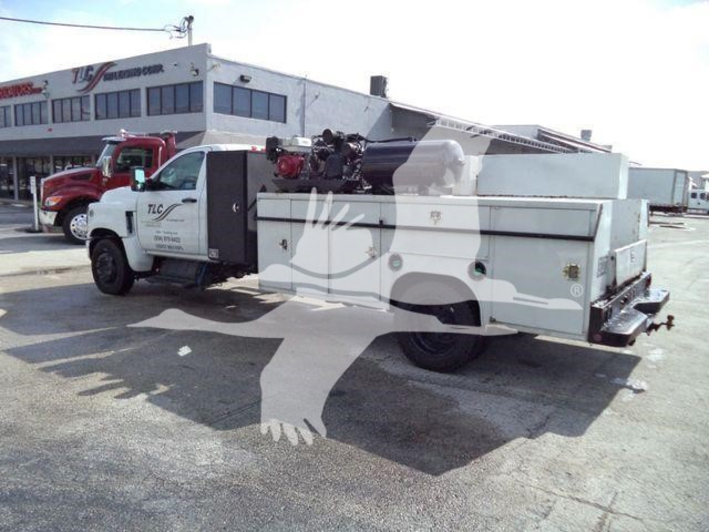Service/utility truck with crane equipment and storage compartments on bed, side view showing crane and equipment bay doors.