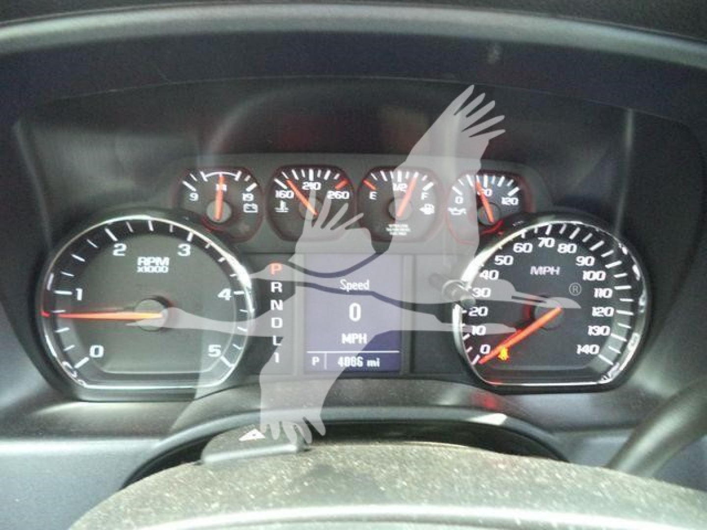 Truck instrument cluster with speedometer, tachometer, and digital display showing P R N D L and 0 mph, 4986 mi, in-service vehicle.