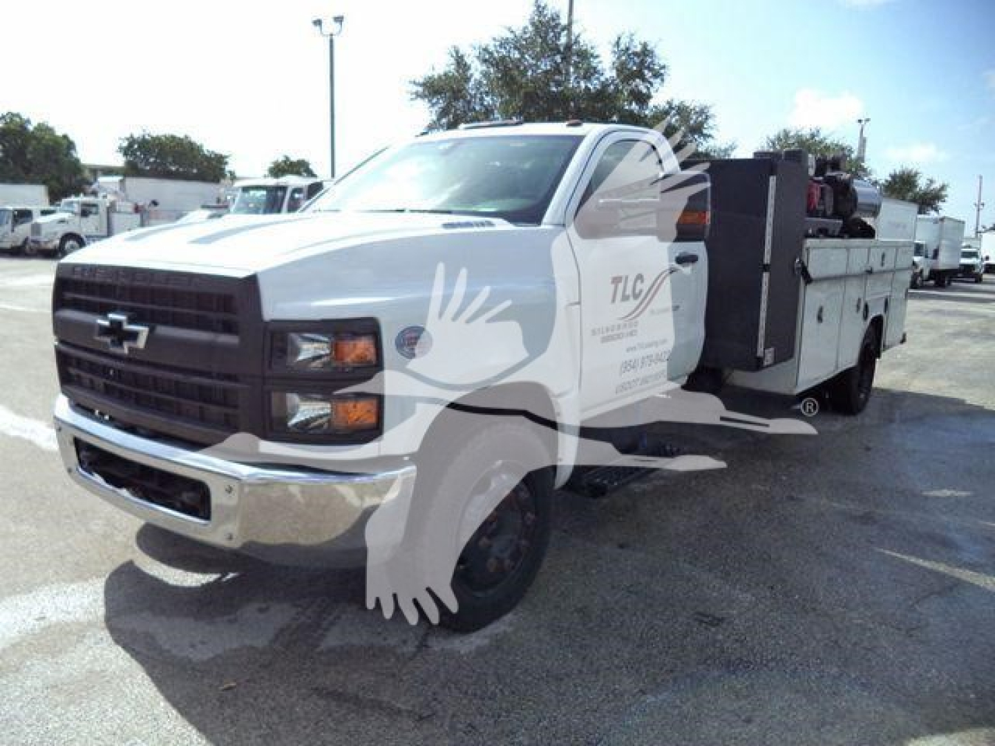 Chevrolet Silverado 6500HD service/utilities truck in white, front three-quarter view, utility bed with compartments.