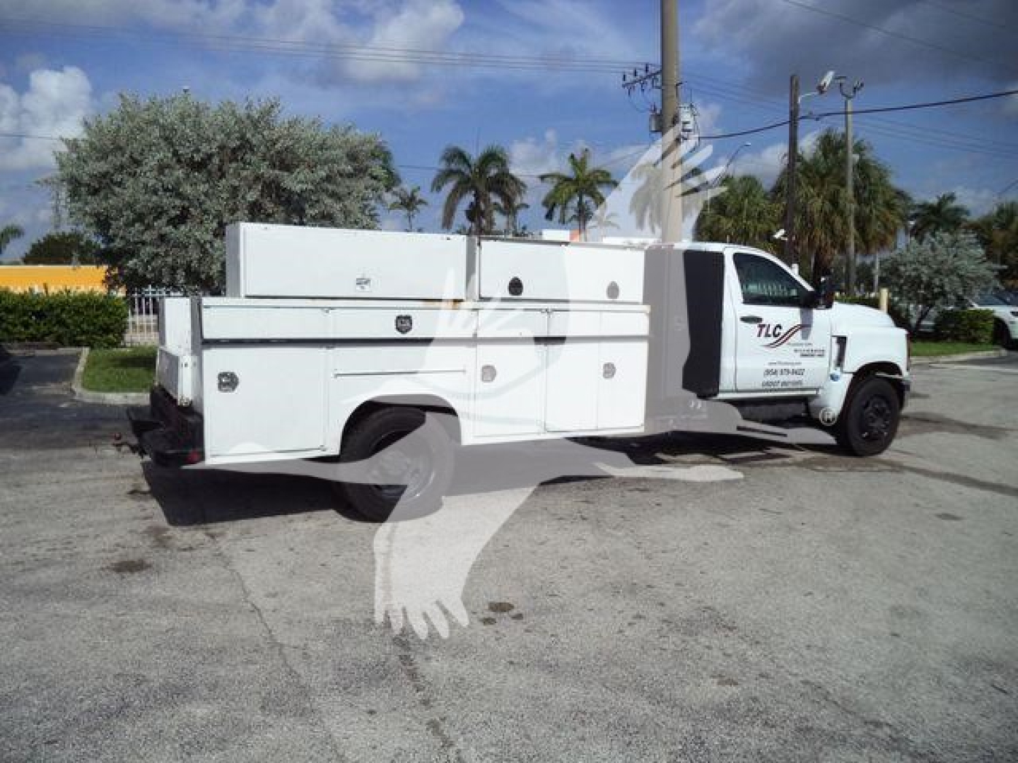 Truck showing service utility utility body with compartments and storage, white Chevrolet Silverado 6500HD style chassis, side view.