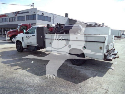 Service/utility truck with crane equipment and storage compartments on bed, side view showing crane and equipment bay doors.