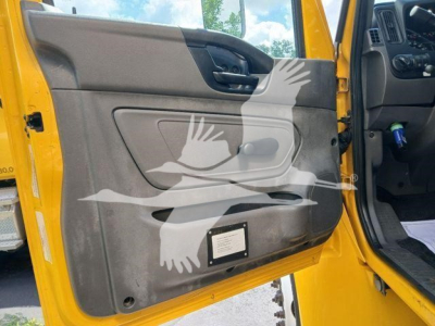 Truck interior door panel view with yellow exterior; front passenger door open, armrest, window switch, storage pocket, and a small vented panel near bottom.