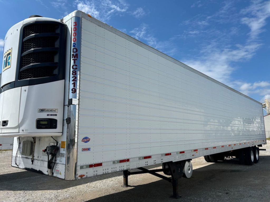 Utility reefer trailer side view showing refrigerated trailer with white exterior, front refrigeration unit, and landing gear.