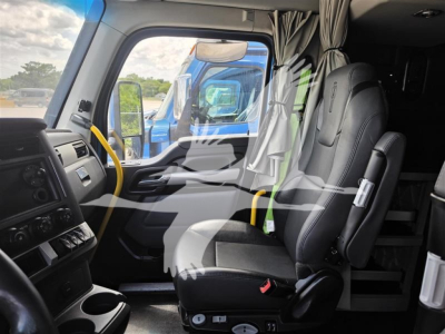 Truck cab interior view of a Kenworth T680 with black cloth front seats, yellow steering wheel rim accents, dashboard controls, and partition behind seats.
