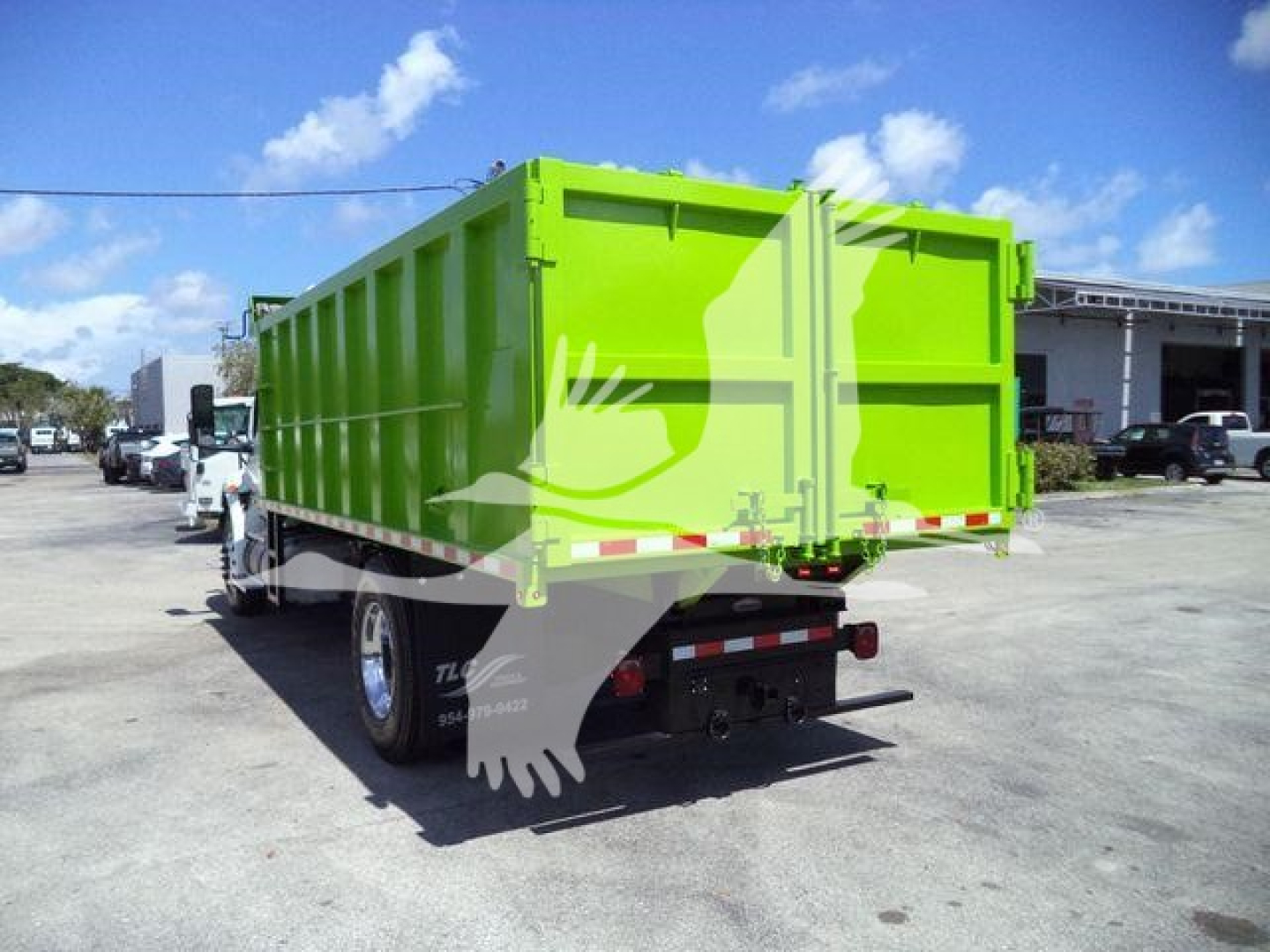 Dump truck rear view showing bright green dump bed and tailgate with 2020 International MV truck.