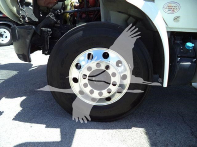 Truck wheel and front fender area of a 2020 International MV dump truck showing a steel with chrome lug nut hub and tire.