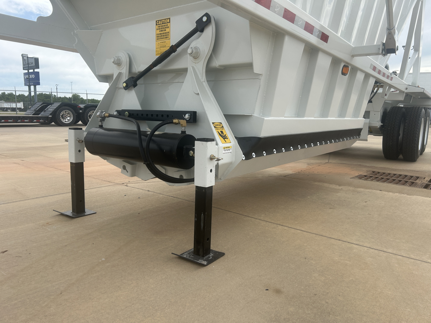 Trailer landing gear and hydraulic actuator on Armor Lite SBD40 air-skeleton dump trailer showing support legs and frame components.