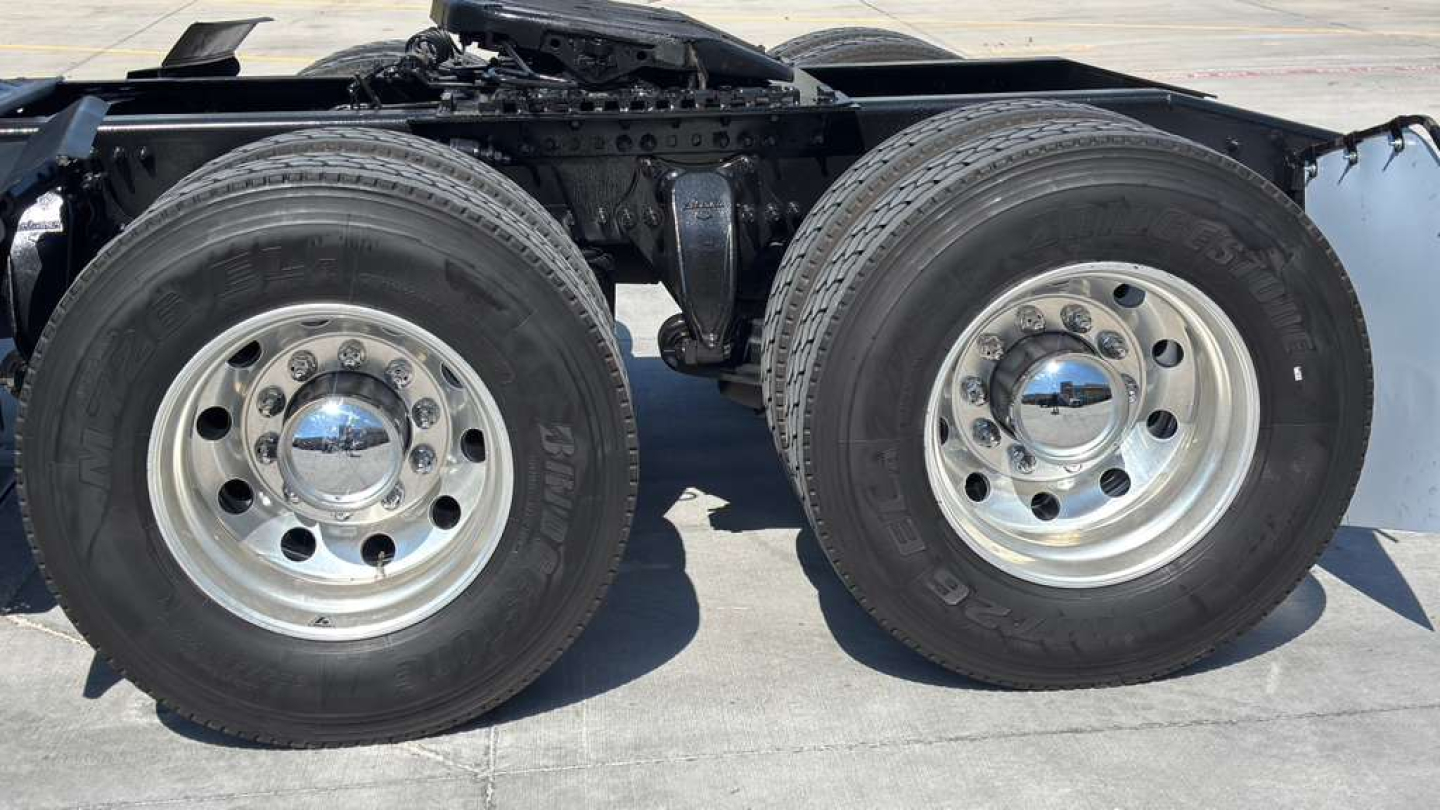 Heavy-duty dual rear axle on Freightliner PT126064ST showing dual 22.5 inch wheels with polished chrome center hubs and tires.