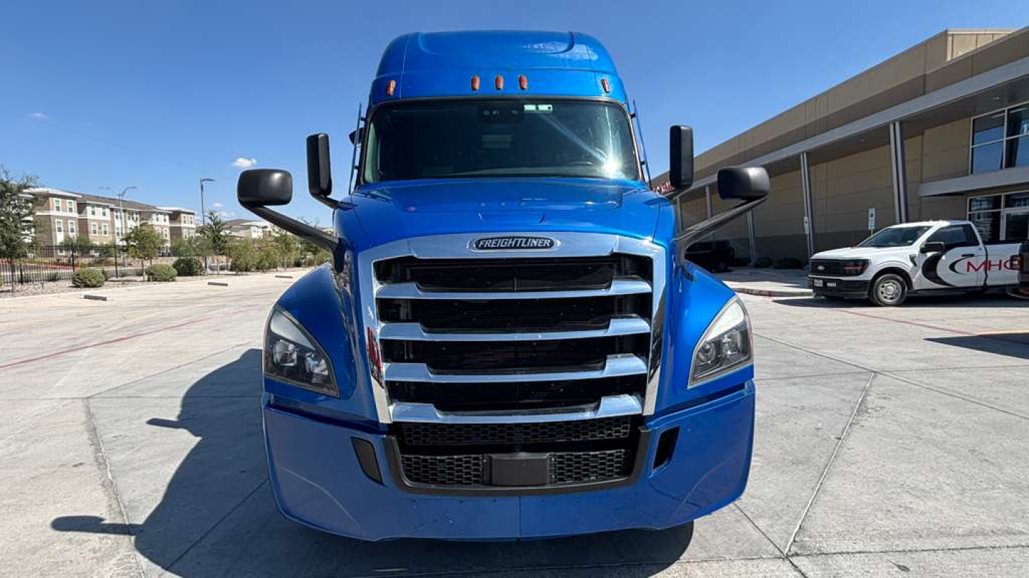 Front view of a blue Freightliner PT126064ST truck showing bold grille, headlights, and side mirrors.