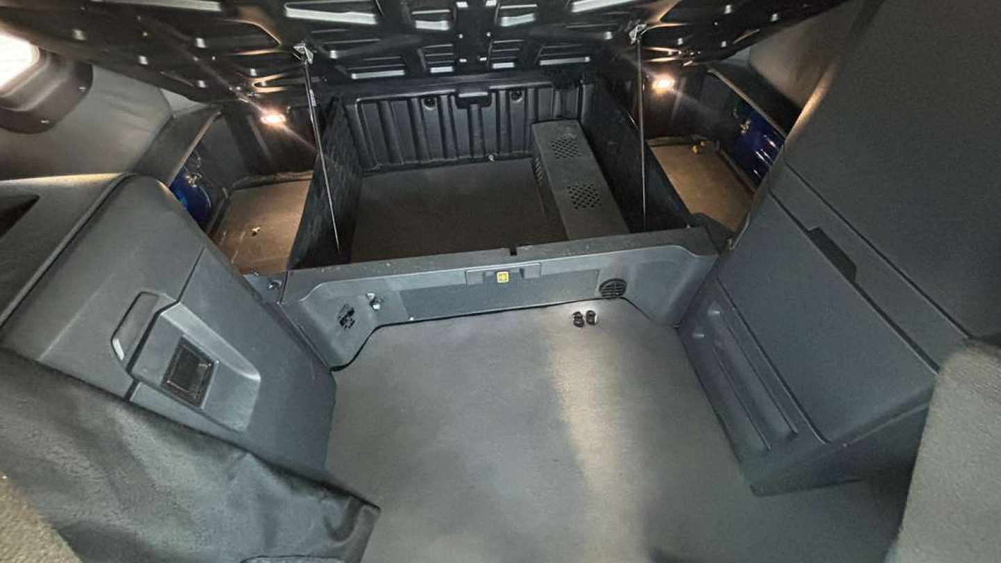 Truck cab interior cargo area of a Freightliner PT126064ST showing rear storage compartments and cabin floor with side panels.