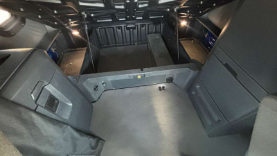 Truck cab interior cargo area of a Freightliner PT126064ST showing rear storage compartments and cabin floor with side panels.