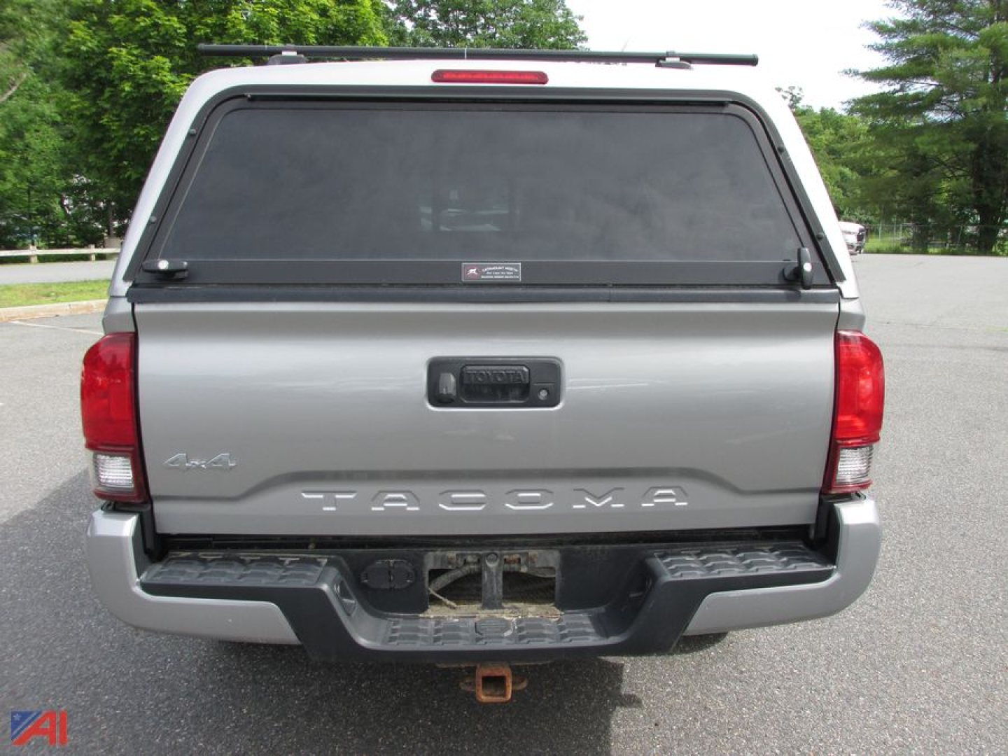 Toyota Tacoma tailgate view showing rear of extended cab pickup with tonneau cover and tow hitch.