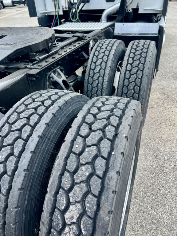 Kenworth T680 truck chassis showing dual rear axle tires and undercarriage components.