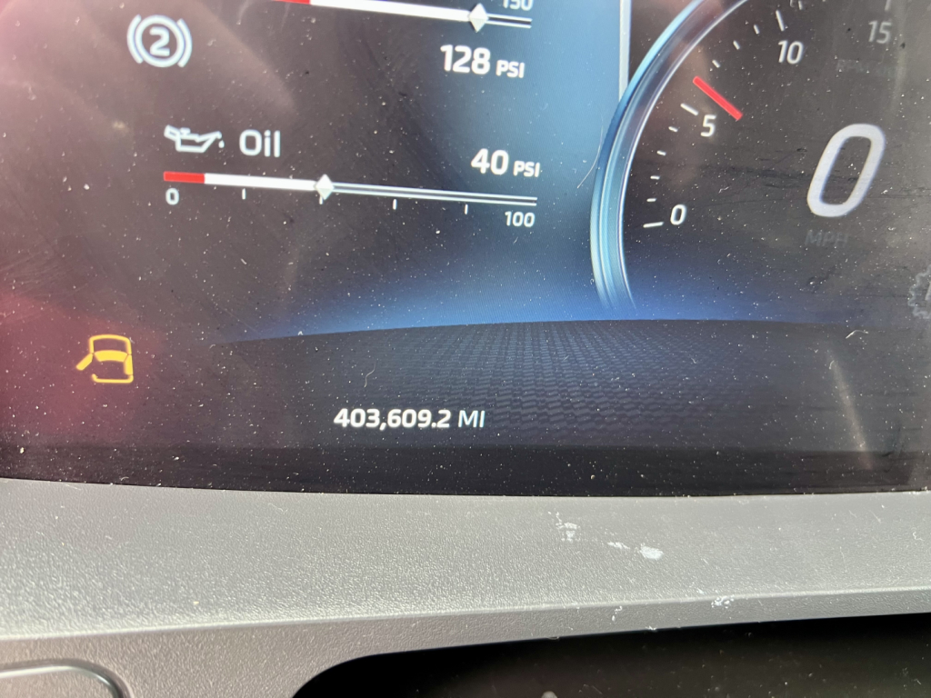 Dash of a 2024 Kenworth T680 with digital gauge cluster showing oil, PSI readings, and 403,609.2 miles.