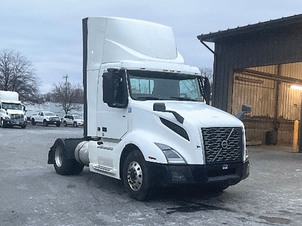 Volvo VNR 300 daycab tractor front-left side view with white cab, no trailer, visible grille and Volvo emblem.
