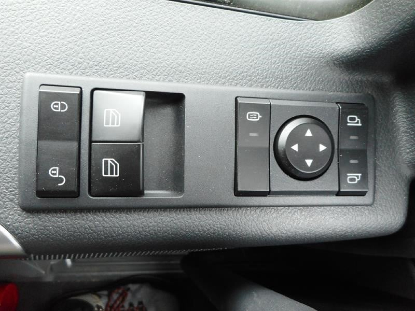 Dashboard window control panel in a Western Star 47X showing multiple switch buttons and a circular joystick control, with square window switch icons.