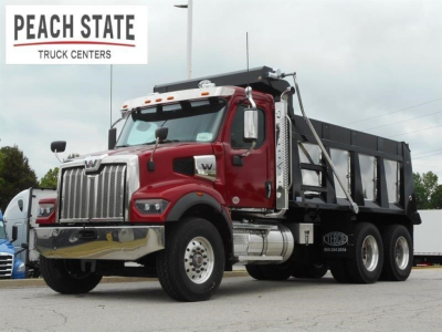 Western Star 47X dump truck in red cab, black dump body, front chrome bumper and grille, company logos, in-service vehicle at Peach State Truck Centers.