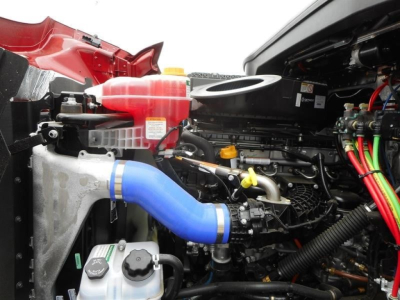 Western Star 47X engine bay showing blue silicone intake hose, coolant reservoir, yellow-handled dipstick, and electrical harnesses.