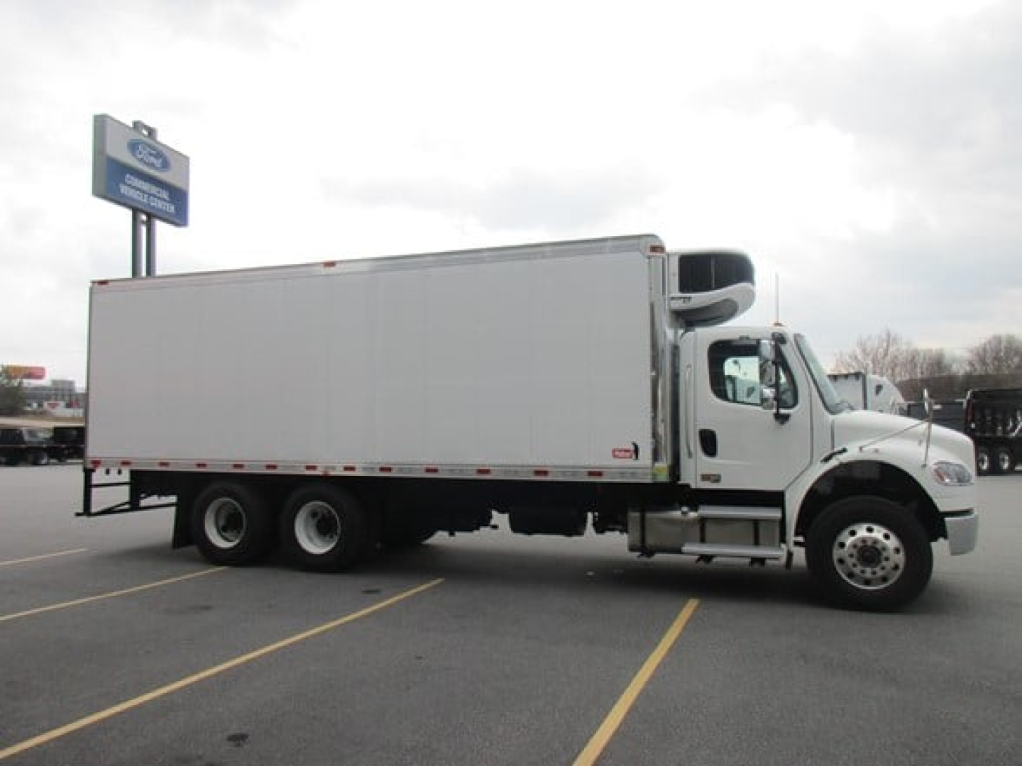 Freightliner M2 106 Plus refrigerated truck side view showing cargo box and cab.