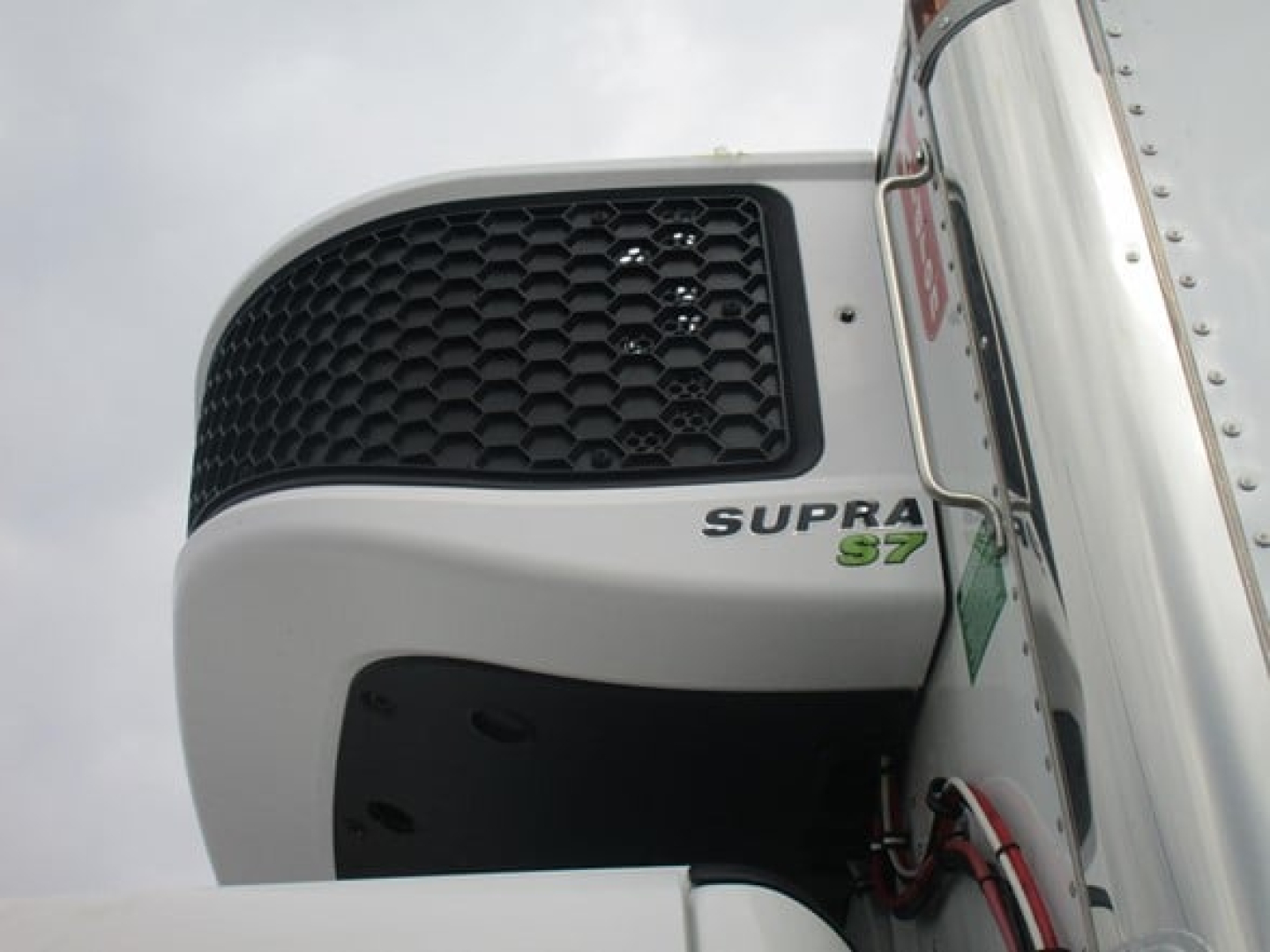 Freightliner M2 106 Plus front grill and Supra S7 refrigeration unit mounted on truck.