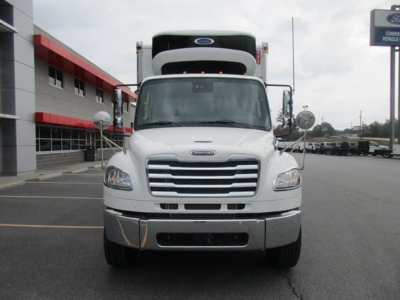 Front view of a white Freightliner M2 106 Plus refrigerated truck showing grille, headlights, and cargo reefer unit on top.