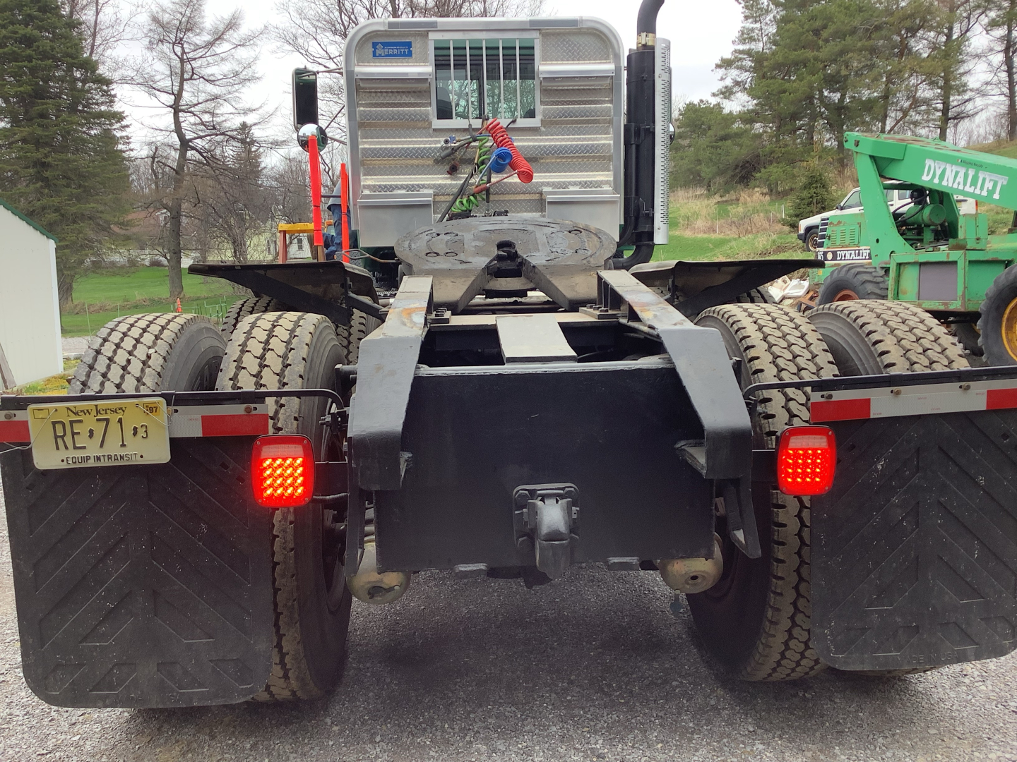 Rear view of a used 1994 Mack RD8 truck chassis showing dual rear axles, taillights, mud flaps, and hitch assembly.
