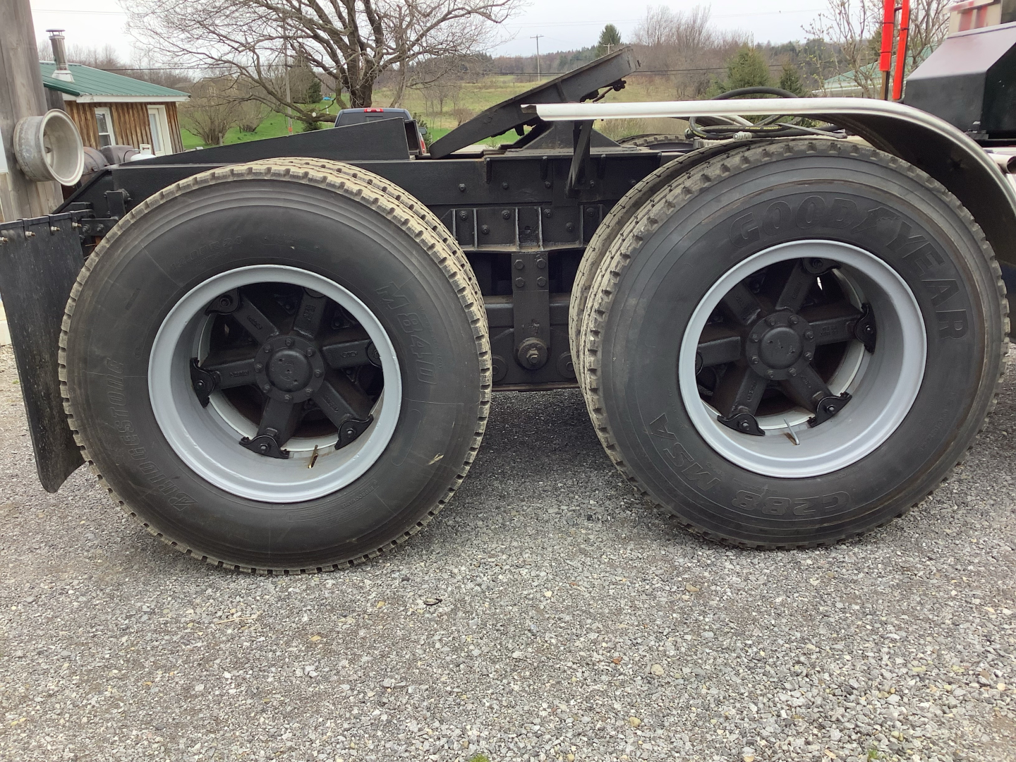 Mack RD8 truck axle with dual rear wheels showing tires and wheel hubs.