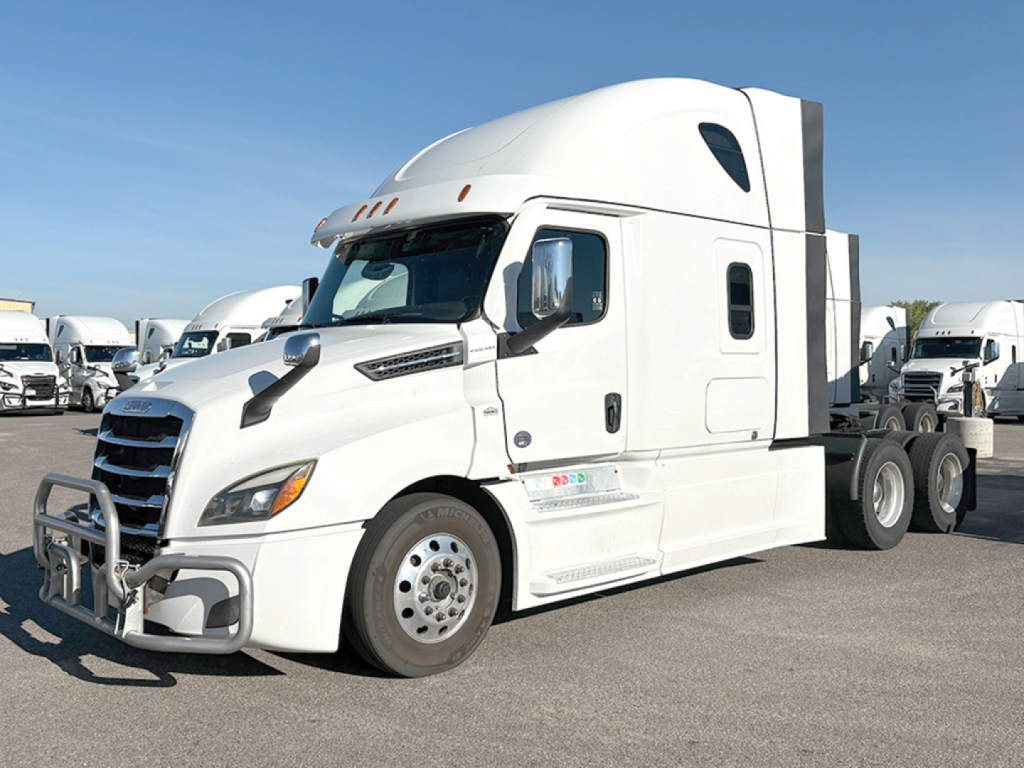 Truck showing Freightliner Cascadia 126 sleeper with company decals on door and side panels. Front bumper guard visible.