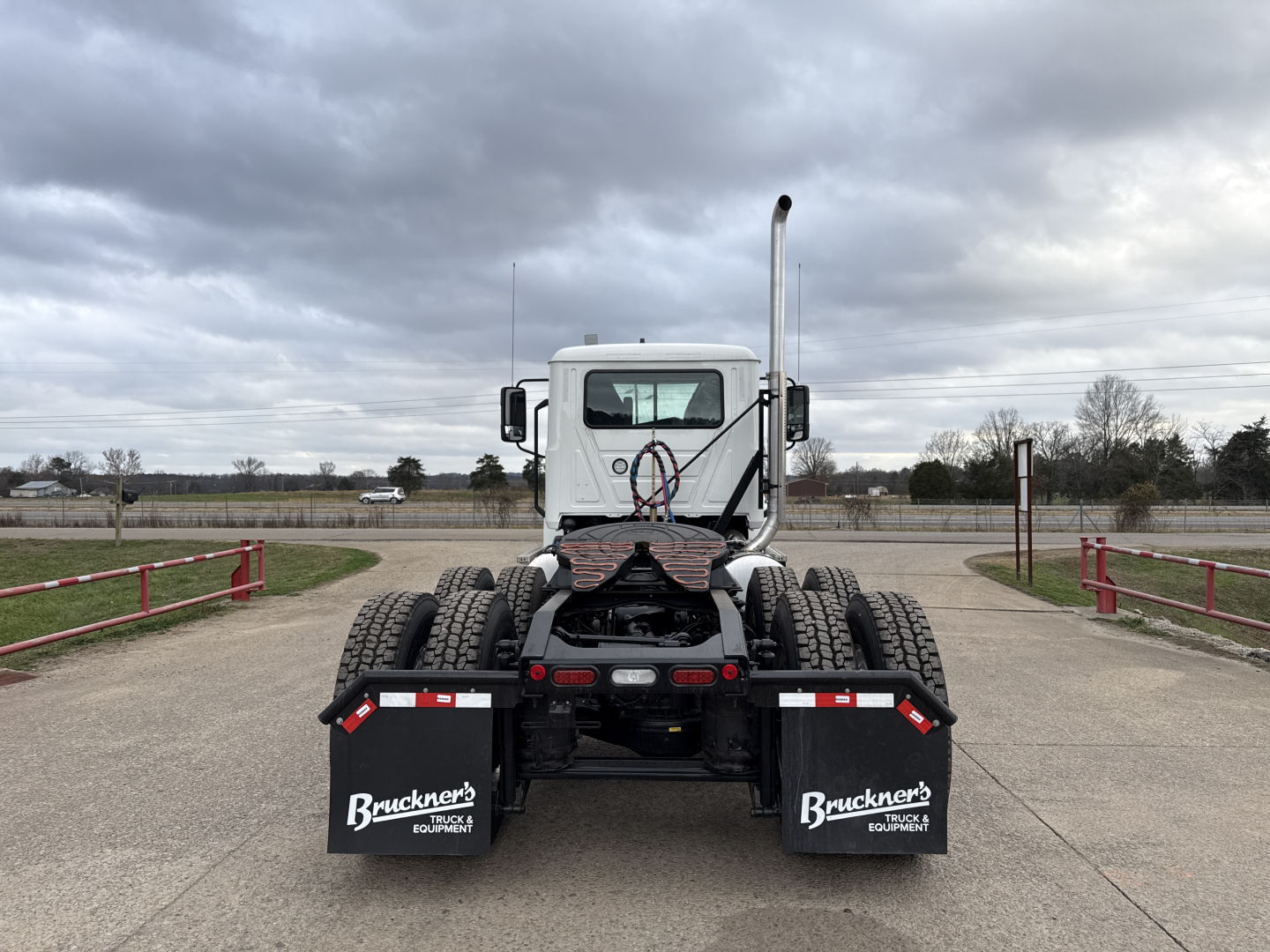 Truck chassis rear view showing dual rear axles and mudflaps with Bruckner's Equipment branding.