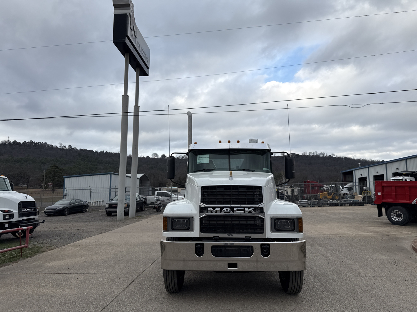 Front view of a white 2026 Mack PI64T conventional daycab truck showing Mack grille and bumper.