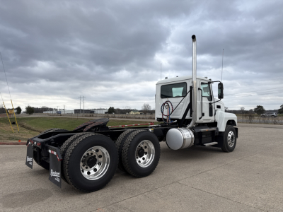 Mack PI64T conventional daycab tractor showing side view with dual rear axles and tall exhaust stack.