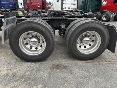 Mack AN64T chassis with dual rear axles and silver wheels, view of rear wheel area and frame rails.
