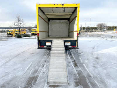 GMC Savana truck with rear ramp extended into cargo area showing empty box and loading ramp.