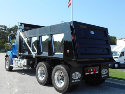 Western Star 47x dump truck in serviceable condition with black dump bed and dual rear axles, side mirrors, and reflective decals.