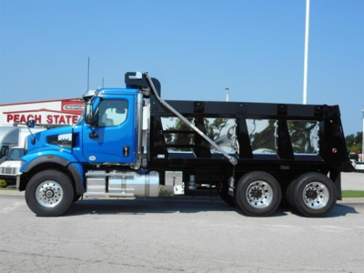 Western Star 47x dump truck side view showing blue cab and black dump body with dual rear axles.