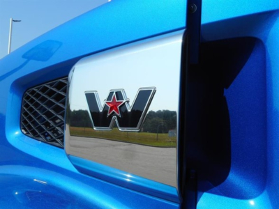 Blue Western Star truck frontend with chrome grille badge showing W emblem and star.