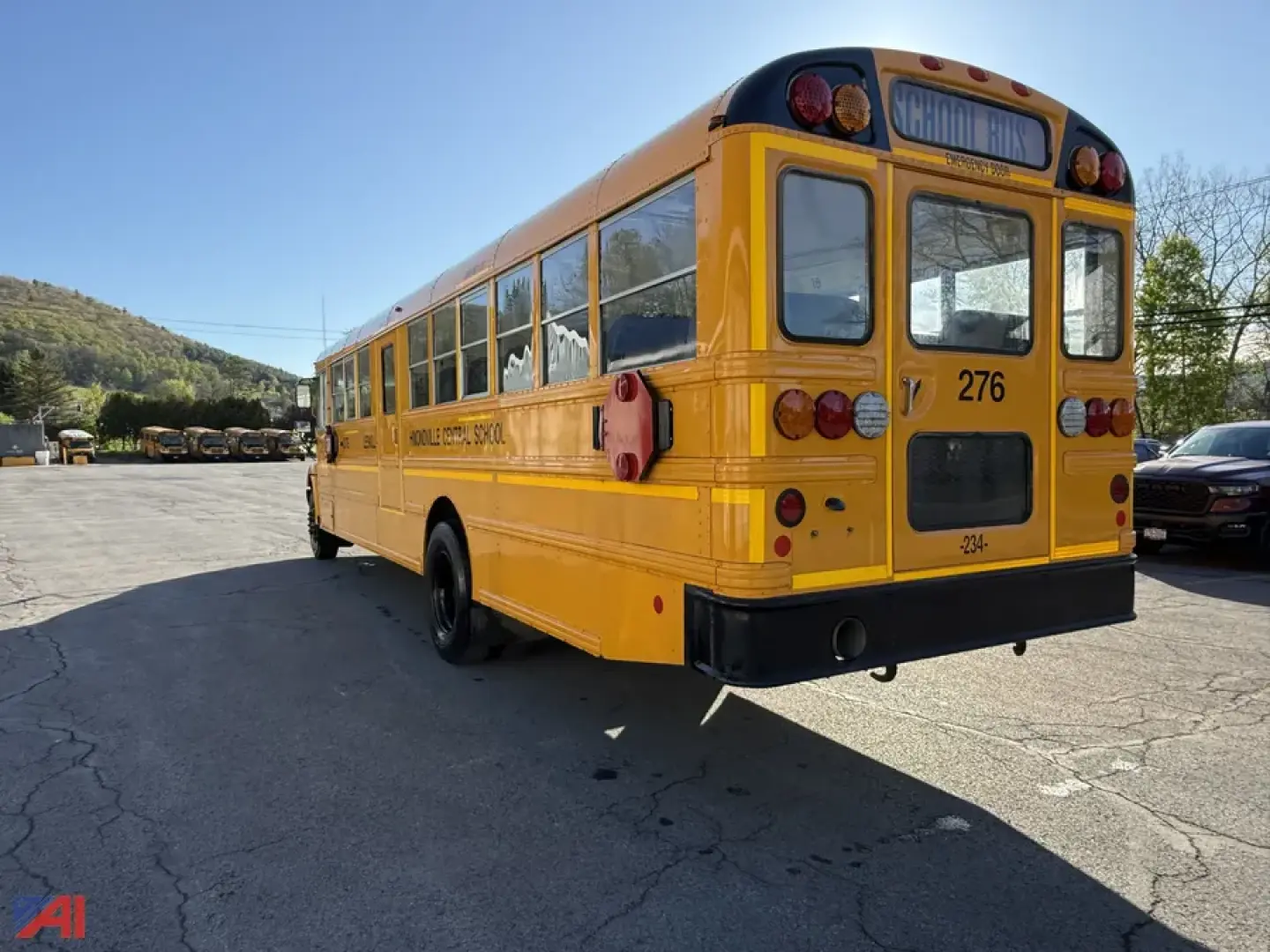 Rear/side view of a yellow IC Corporation CE Series school bus with the number 276, text on side reads SCHOOL BUS, red stop sign extended, black bumper, rear window, and taillights.