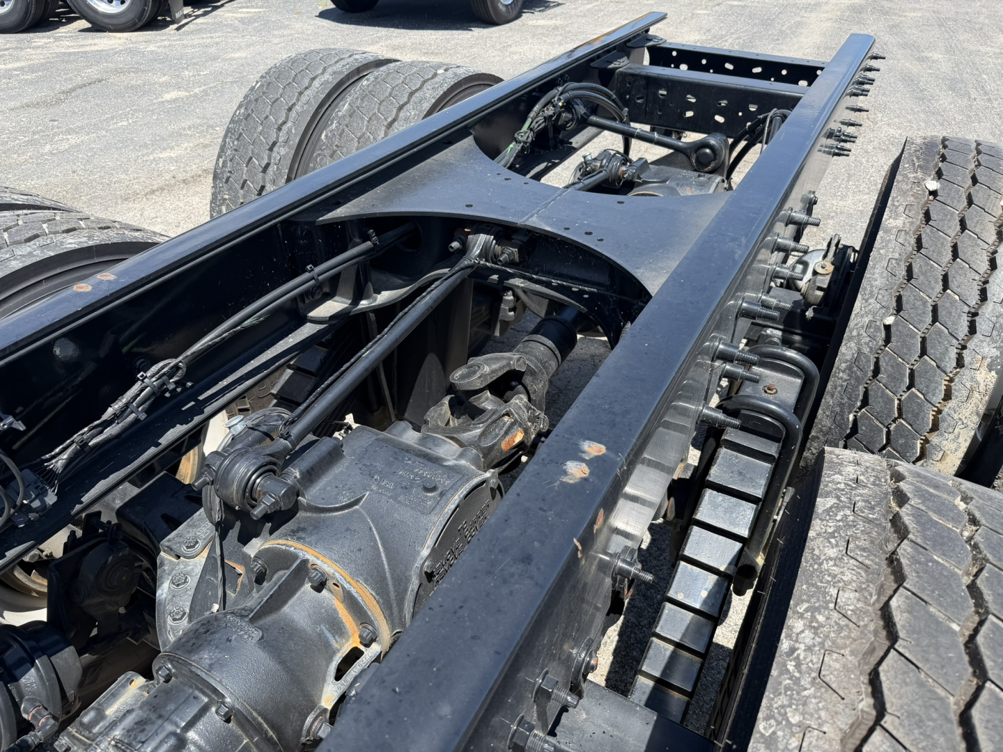 Truck chassis frame showing drivetrain and suspension components of a 2025 Mack GR64F cab and chassis.