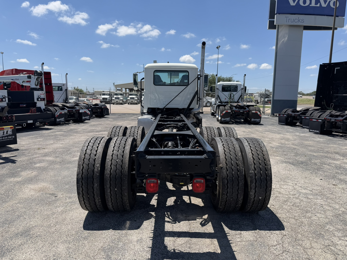 Mack GR64F chassis rear view showing dual rear axles and connection frame.