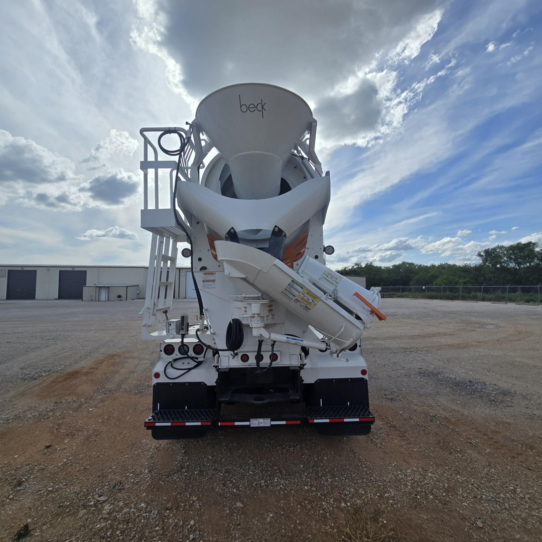 Mixer truck rear view showingBeck concrete mixer chute and rear chassis with tires and hydraulic components.