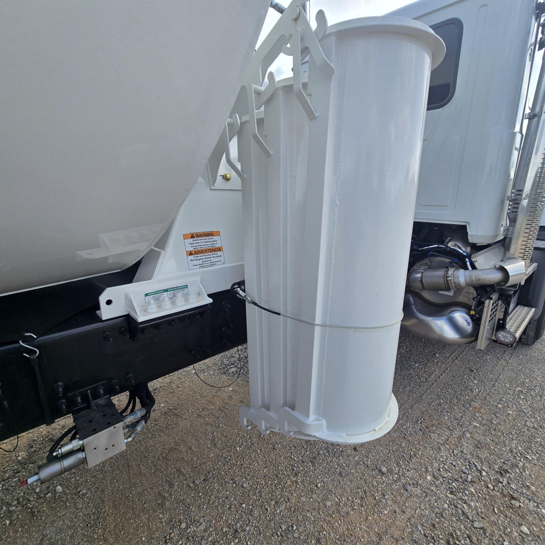 Mixer truck side with vertical cylindrical exhaust/air filter and frame components visible near rear; shows cement mixer body and chassis.