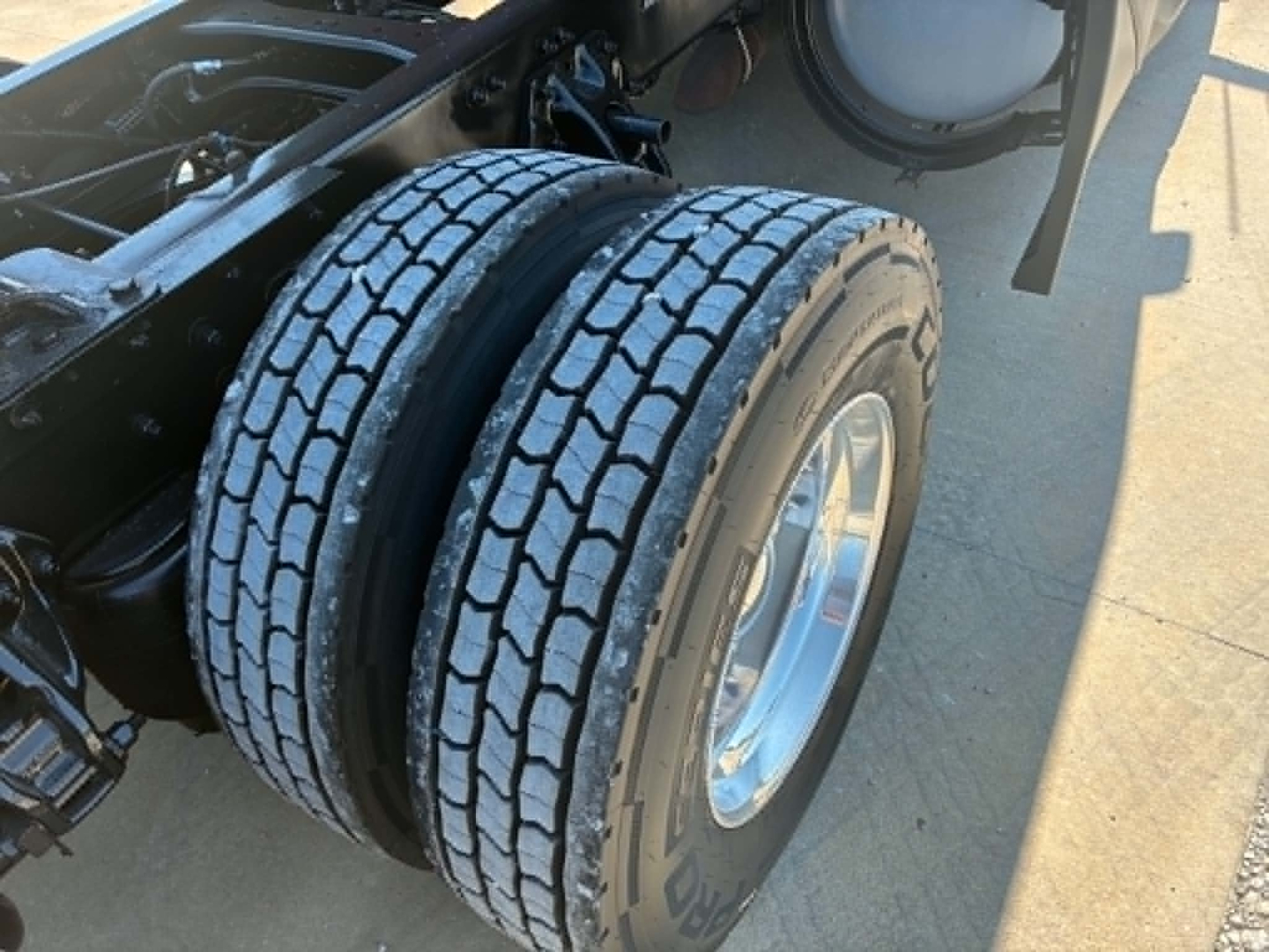 Kenworth T680 truck rear dual tires and wheel setup with exposed frame and undercarriage components.