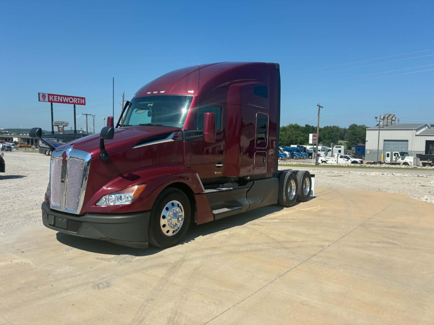 Kenworth T680 tractor in maroon showing front grille with Kenworth badge and side mirrors.