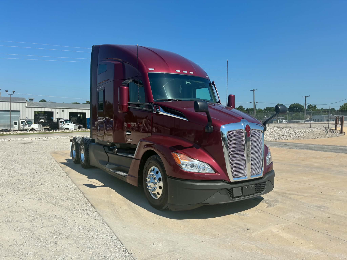 Kenworth T680 tractor in burgundy showing chrome grille, headlights, and side mirrors; cab aerodynamic design; no visible text on labels.