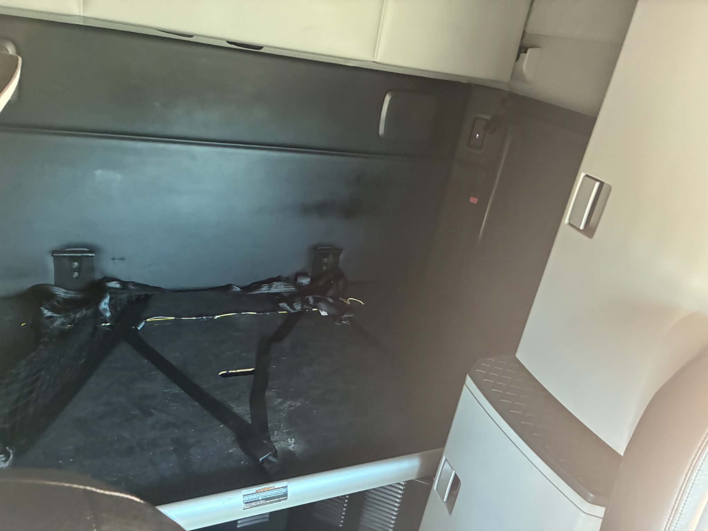 Kenworth truck interior cargo area with hitch/rail and framed underside view. Visible labels unreadable; no clear engine or exterior text.