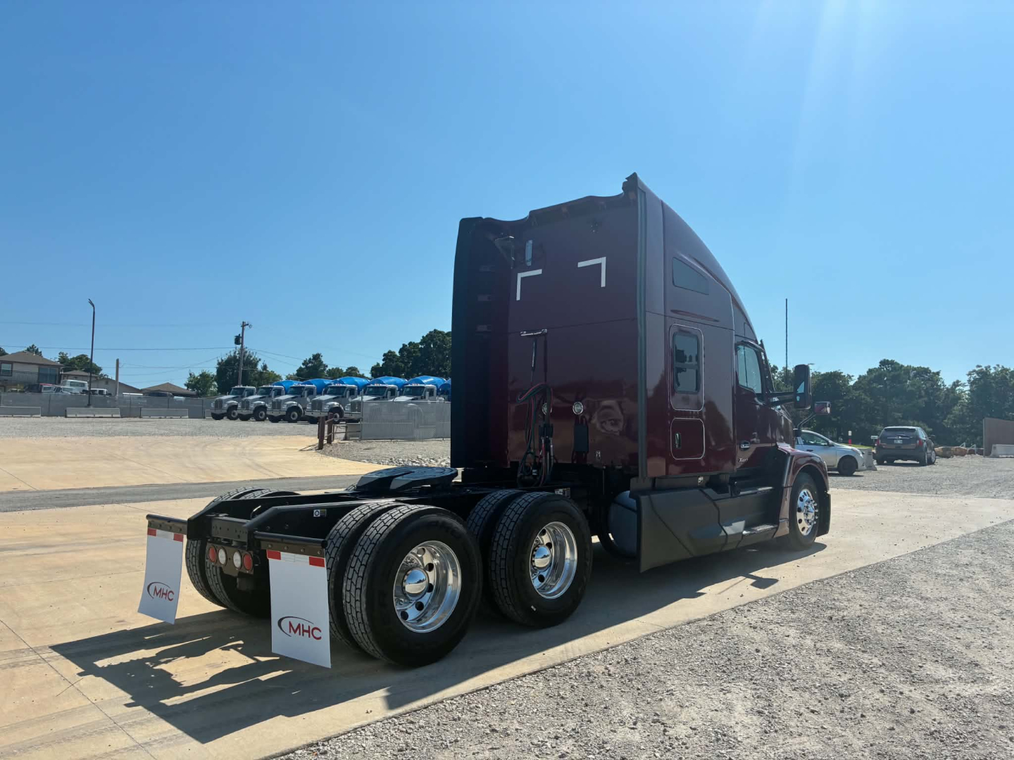 Kenworth T680 tractor-trailer chassis from rear-side view showing dual rear axles, maroon sleeper cab, and visible stock tag; exterior features include fuel tanks and tires.